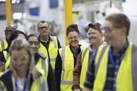 Group of workers in high visibility vests and safety glasses.