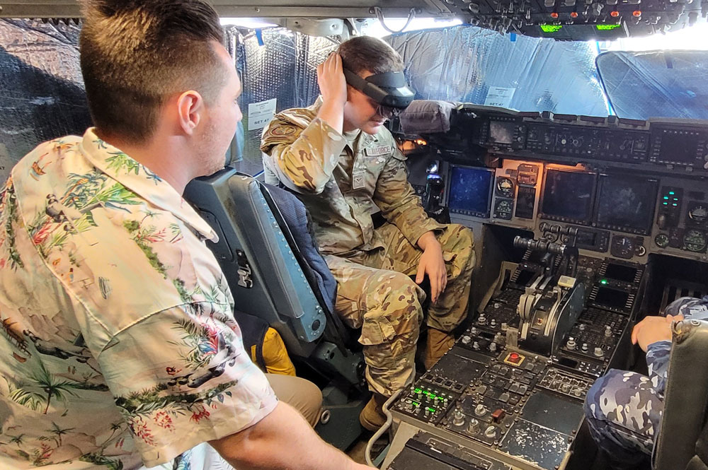 Boeing Australia FSR Luc de Leacy (left) and USAF Airman First Class Anthony Cardoni on the flight deck of a USAF C-17 during a field test of Boeing’s ATOM technology.