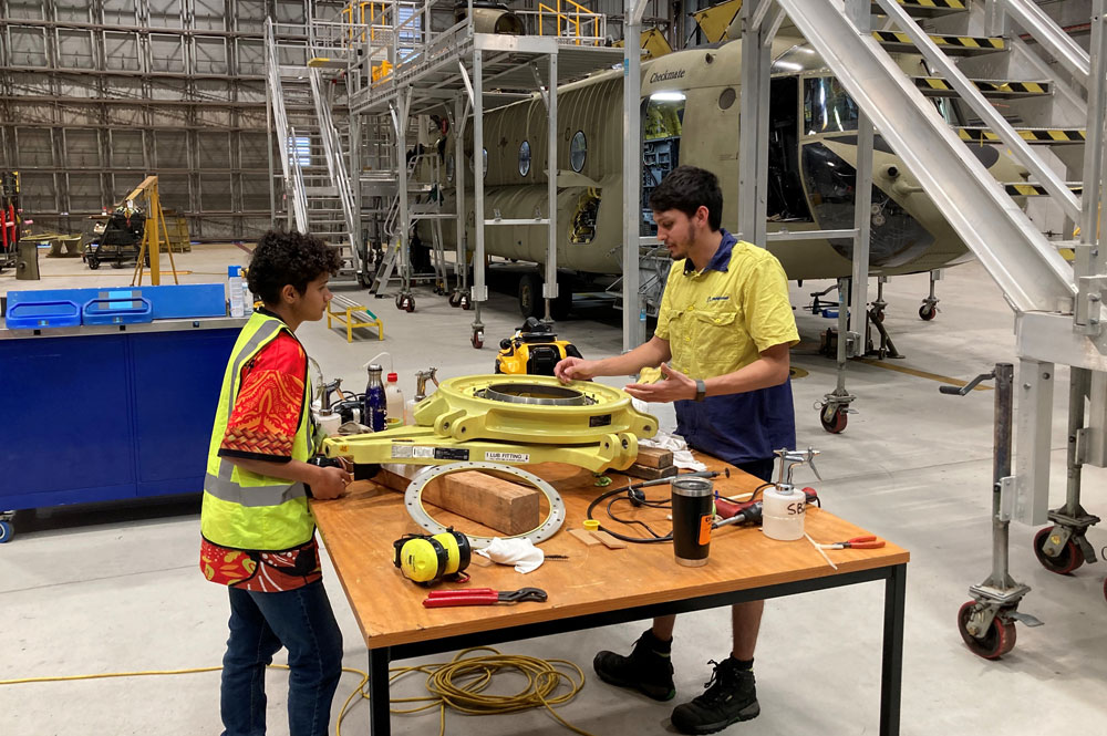 Boeing Indigenous maintenance engineer Kari Sigurdsson (right) shows Elizabeth Ludwick a critical component of the CH-47F flight control system during her work experience.