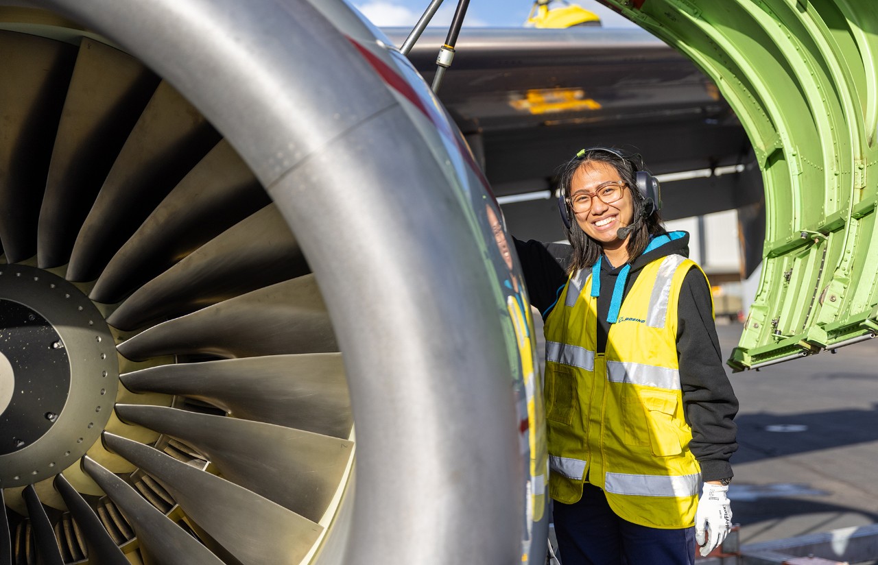 Woman in safety gear standing near P8 engine cowling